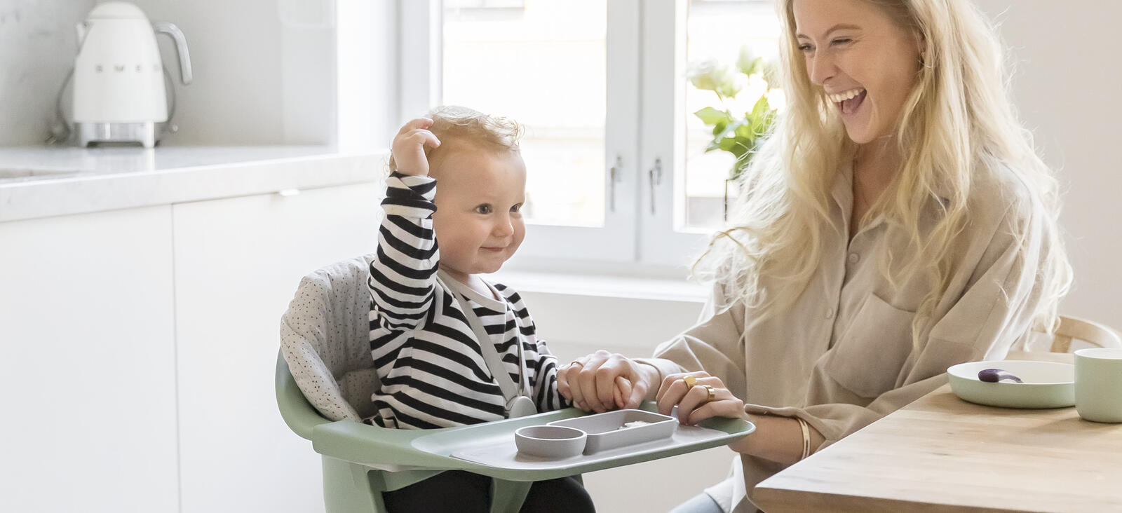 Baby smiling with mother in Clikk Chair