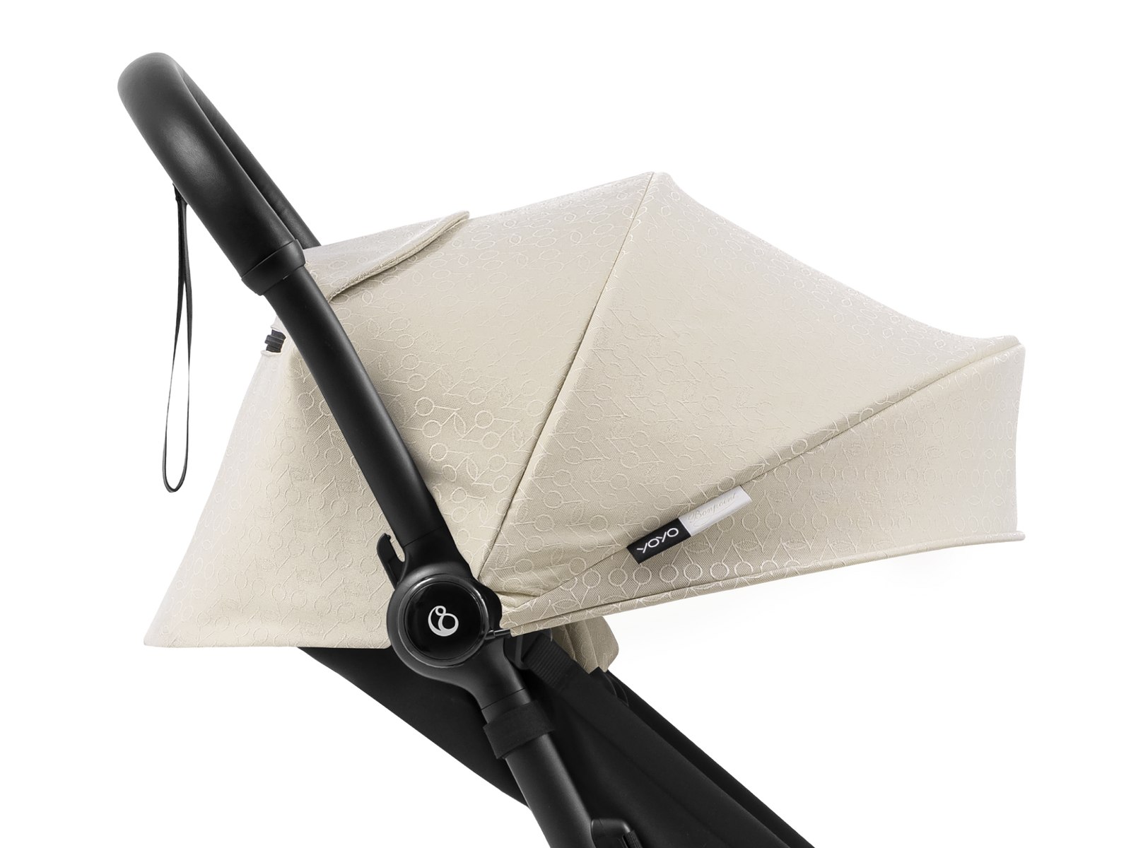 Close-up of a STOKKE YOYO Bonpoint stroller's beige patterned canopy and black handle.
