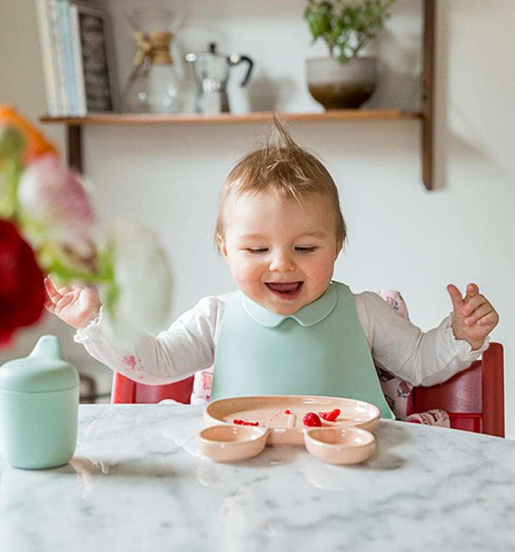 Lächelndes Baby beim Mittagessen