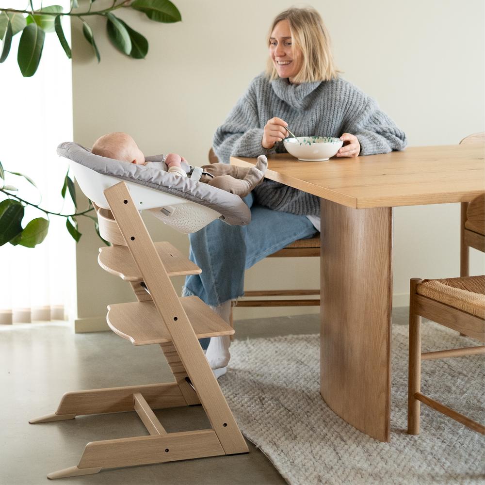 Mom at kitchen table with her baby in tripp trapp newborn set.