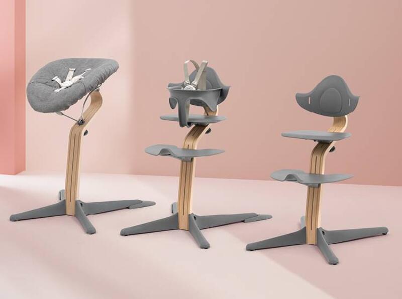 Lineup of Stokke® Nomi® chair with newborn set, Stokke® Nomi® chair with baby set, and Stokke® Nomi® chair.