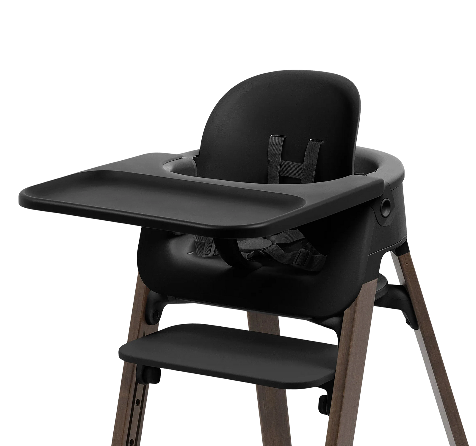 Black high chair with a tray, seat, footrest, and wooden legs on a black background.