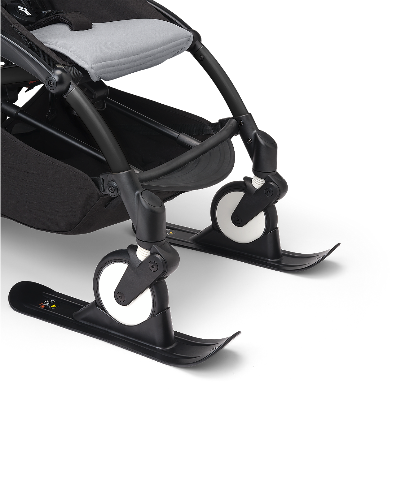 Poussette STOKKE YOYO avec des attaches de ski noires sur ses roues avant.
