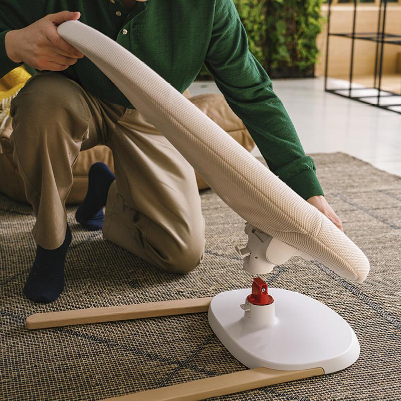 Father is showcasing the easy assembly process of the Stokke Yoga