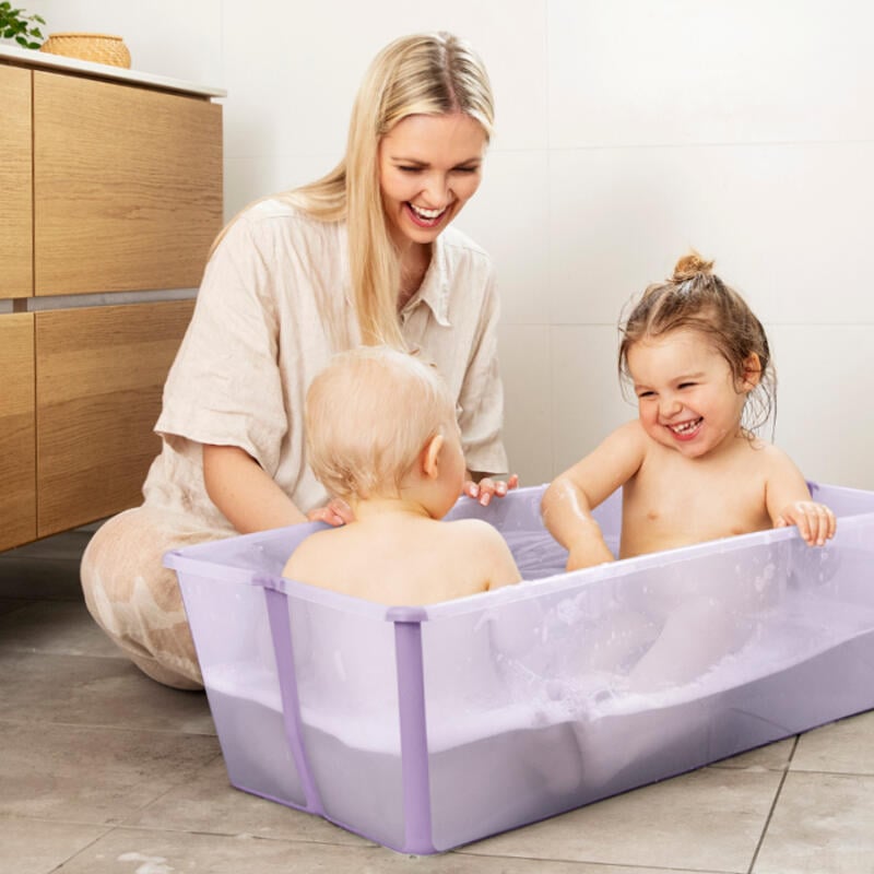 Hermanos compartiendo un baño en la bañera flexi XL en color lavanda bajo la supervisión de mamá.