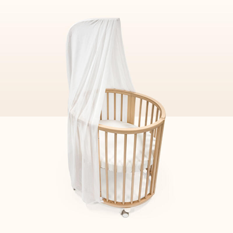 Sleepi mini crib in color natural with white mattress and white canopy. 