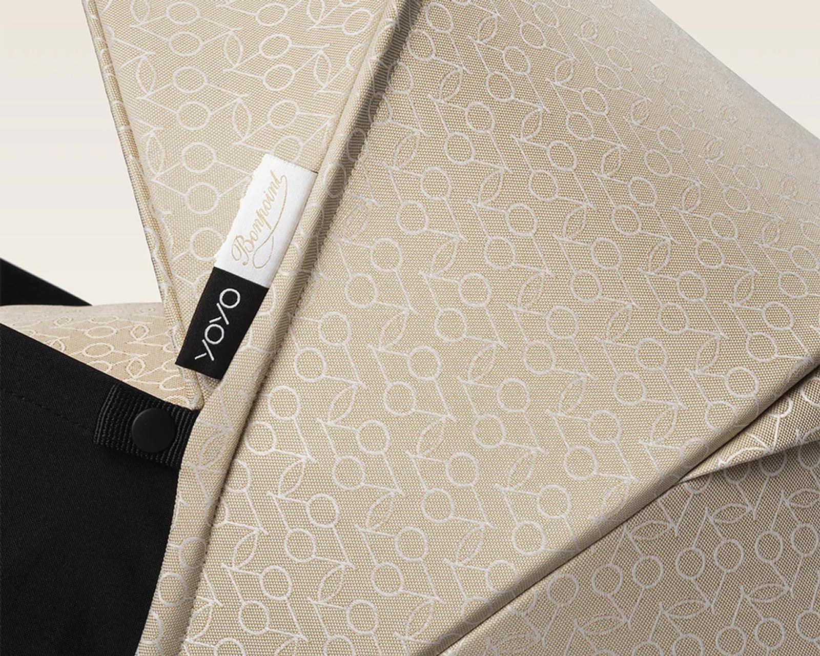 Close-up of a STOKKE YOYO stroller hood in beige with white cherry pattern and Bonpoint label.