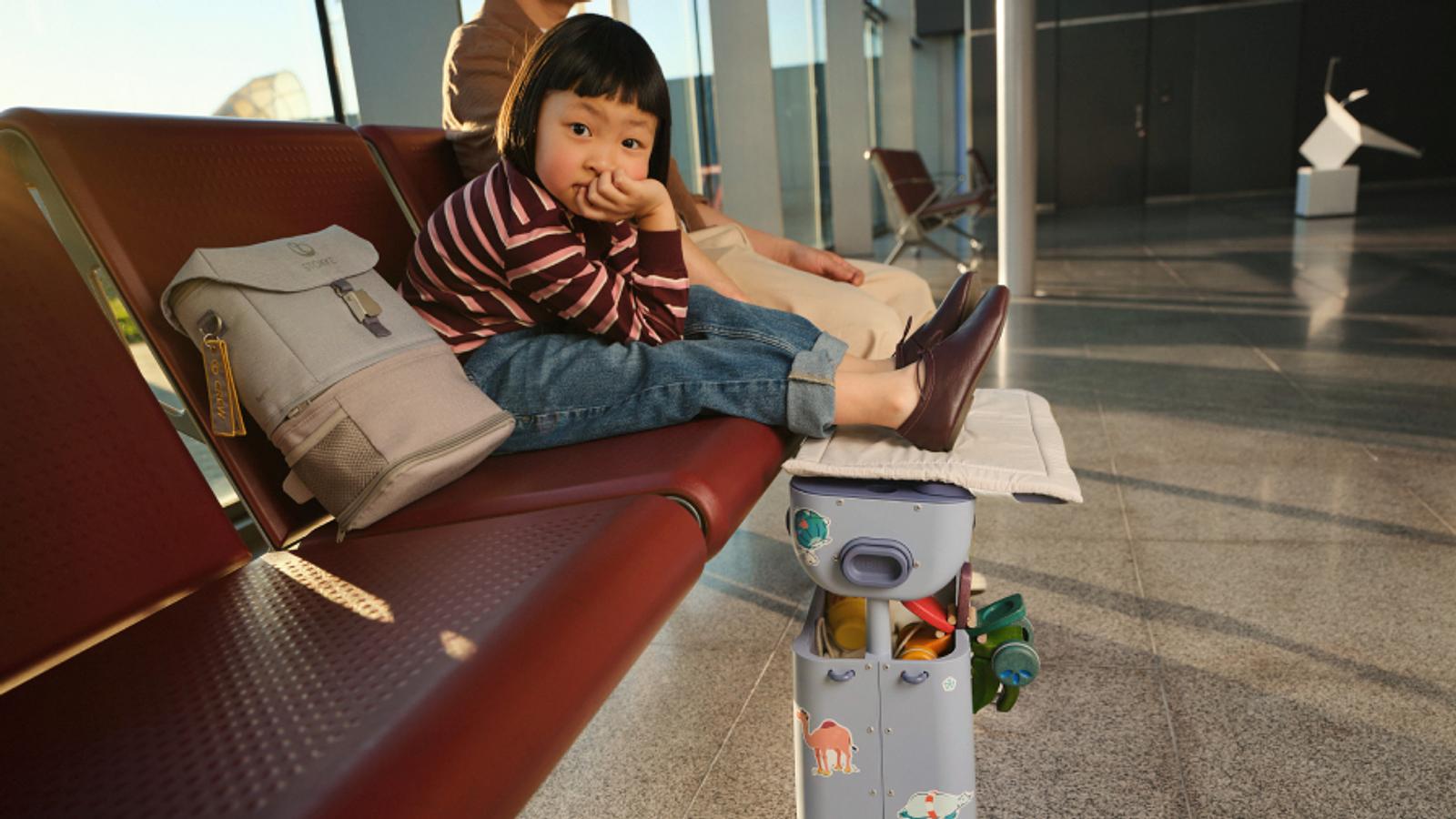 Child sitting in airport resting their legs on the BedBox