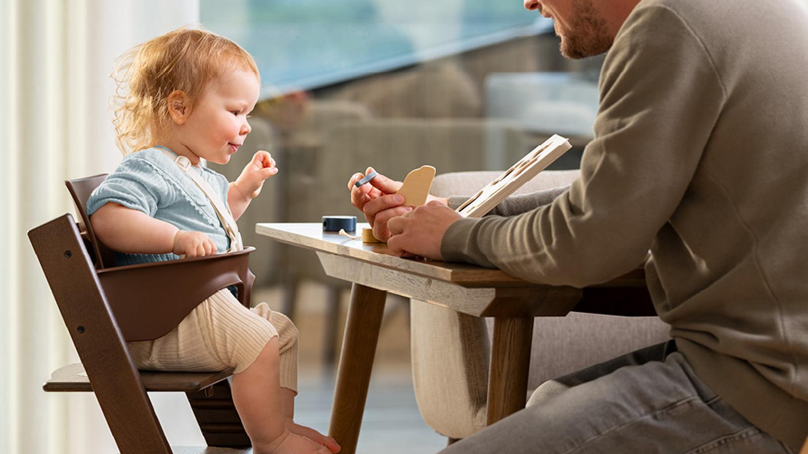Mom looking at her newborn in the sleepi mini crib.