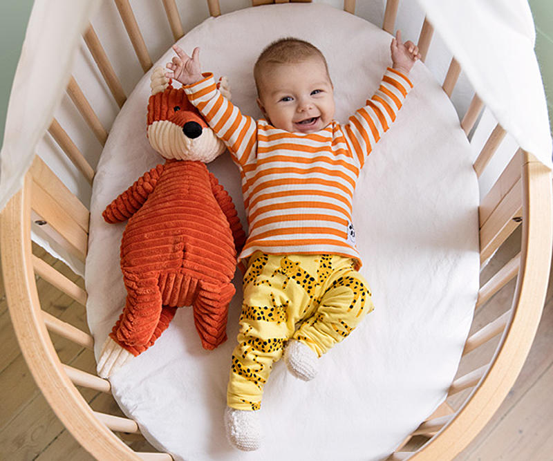 Fröhliches Baby im Stokke Sleepi Bett