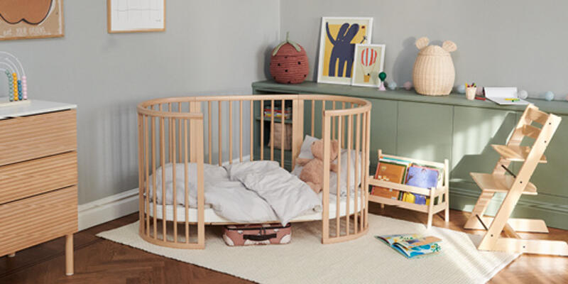 A child's nursery with the natural sleepi bed, tripp trapp chair and dresser.
